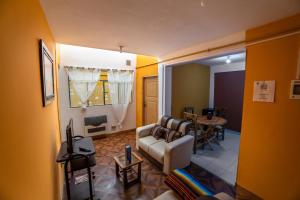 The Little House ApartHotel في أويوني: غرفة معيشة مع أريكة وطاولة
