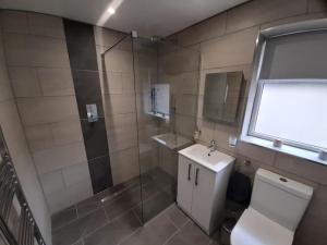 a bathroom with a toilet and a shower and a sink at Home in Harrogate in Harrogate