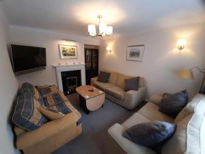 een woonkamer met banken, een tv en een open haard bij Home in Harrogate in Harrogate