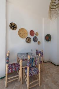 une table et des chaises avec des assiettes sur un mur dans l'établissement Riad SULTANA, à Tanger