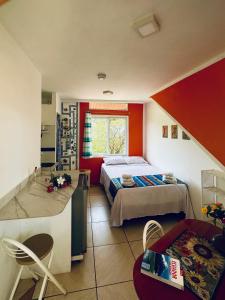 a small bedroom with a bed and a table and chairs at CASA MOSAICO in Puerto López