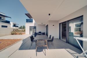 an outdoor dining area with a table and chairs at Funtana Villas an der 1 Reihe vom Meer in Funtana