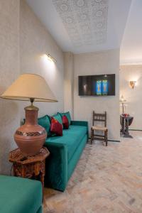 uma sala de estar com um sofá verde e um candeeiro em Riad SULTANA em Tânger