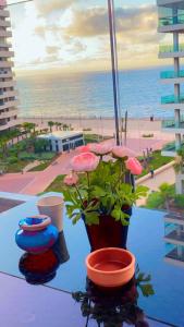 a table with flowers on it with a view of the beach at MARINA APARTMENT OCEAN VIEW in Casablanca