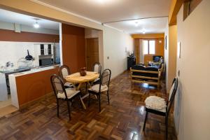 The Little House ApartHotel في أويوني: مطبخ وغرفة طعام مع طاولة وكراسي