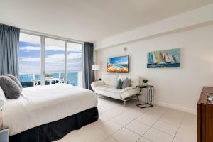 a hotel room with a bed and a couch at Ocean View Balcony steps from Restaurants, Peacock Park & Marina in Miami