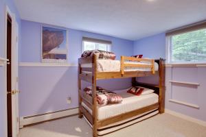 a bedroom with two bunk beds in a blue room at Bethel Chalet with Hot Tub 3 Miles to Sunday River! in Bethel