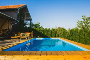 ein Swimmingpool mit Holzterrasse neben einem Haus in der Unterkunft DUGA VIEW in Opornica