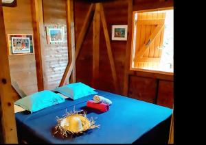 a bedroom with a blue bed with a window at Bungalows du Soleil - Piscine Jardin Fleuri in Le Gosier