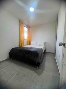 ein Schlafzimmer mit einem Bett in einem Zimmer mit einem Fenster in der Unterkunft Apartamento familiar en itagui in Itagüí