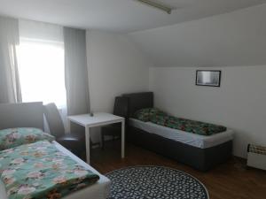 a small room with two beds and a table at ApartGraz in Graz