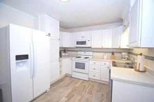 a white kitchen with white appliances and white cabinets at Holiday Cottage Cottage in Ocean City