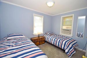 two beds in a room with blue walls and windows at Holiday Cottage Cottage in Ocean City