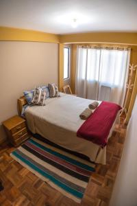 um quarto com uma cama grande e uma janela em The Little House ApartHotel em Uyuni