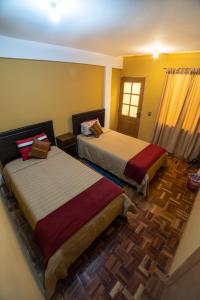 a bedroom with two beds and a window at The Little House ApartHotel in Uyuni