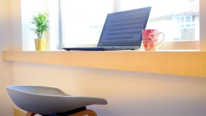 a laptop computer sitting on a shelf next to a window at IH Apartments & Studios in Espinho