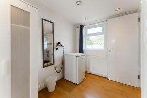 a bathroom with a white refrigerator and a window at Plaistow Cosy Double Rooms - 8 in London