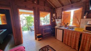 a kitchen in a wooden cabin with a counter top at Bungalows du Soleil - Piscine Jardin Fleuri in Le Gosier
