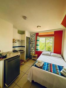a bedroom with a large bed and a kitchen at CASA MOSAICO in Puerto López