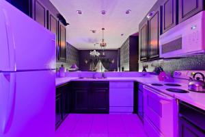 cocina púrpura con nevera y fogones en A Spooktacular Haunted Mansion., en Kissimmee