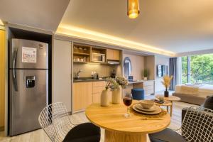 a kitchen and living room with a wooden table and a refrigerator at ULIV Parque Lincoln in Mexico City