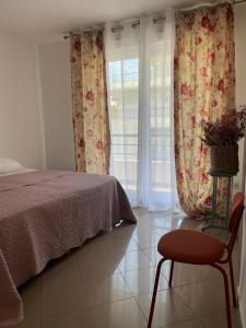 sypialnia z łóżkiem, krzesłem i oknem w obiekcie 2/3 pièces avec terrasse à NICE w Nicei