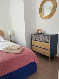 sypialnia z łóżkiem i komodą z lustrem w obiekcie 2/3 pièces avec terrasse à NICE w Nicei