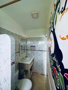 a bathroom with a toilet and a sink at CASA MOSAICO in Puerto López