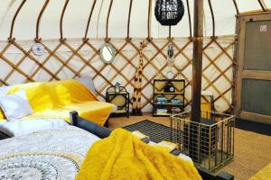 um quarto com uma tenda com um sofá e uma mesa em Bronfelen Yurt em Cynghordy