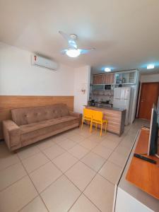 グアラジュバにあるBella casa 10 em Guarajuba, apartamento equipado para você e sua família, tudo que você precisa pra se sentir em casa!のリビングルーム(ソファ、黄色の椅子付)