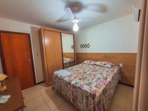 1 dormitorio con 1 cama y ventilador de techo en Bella casa 10 em Guarajuba, apartamento equipado para você e sua família, tudo que você precisa pra se sentir em casa! en Guarajuba