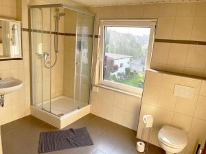 baño con ducha y aseo y ventana en Bavaria Home: Balkon, Küche, Netflix, en Wolnzach