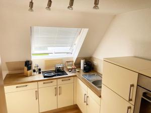 cocina pequeña con fogones y ventana en Bavaria Home: Balkon, Küche, Netflix en Wolnzach