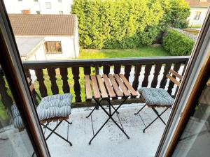balcón con banco de madera y 2 sillas en Bavaria Home: Balkon, Küche, Netflix, en Wolnzach