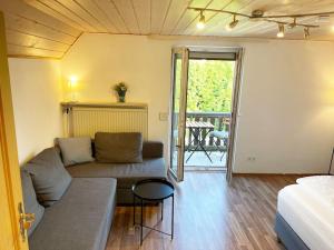 Habitación con sofá, cama y balcón. en Bavaria Home: Balkon, Küche, Netflix, en Wolnzach