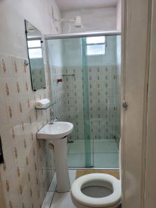 y baño con ducha, aseo y lavamanos. en Pousada Piçarras - Centro Histórico, en Lençóis