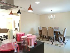 a kitchen with pink stools and a dining room at Casa de férias do Sonho in Santa Cruz Cabrália