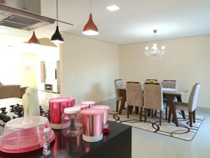 a kitchen with pink stools and a dining room at Casa de férias do Sonho in Santa Cruz Cabrália +7 photos