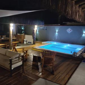 - une piscine dans une chambre avec une table et un canapé dans l'établissement Chalé Ilhabela Apartamento Ilhabela Bangalô Ilhabela Bangô Brasil, à Ilhabela