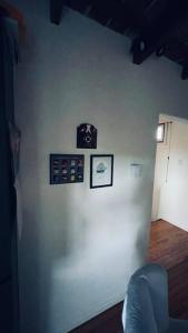 Pokój z białą ścianą z obrazami w obiekcie Preciosa casa con diseño único w mieście Balcarce