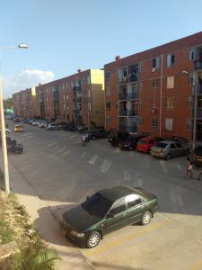 a green car parked in a parking lot with buildings at La casita de Johisfress in Cartagena de Indias