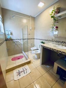 een badkamer met een douche, een wastafel en een toilet bij Plaza Departamentos Temporarios in Formosa