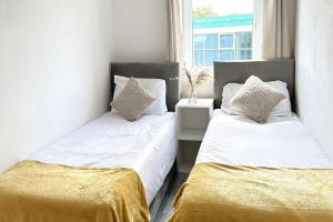 A bed or beds in a room at Cosy 2 Bed Apartment 5 min walk from London Tube Station
