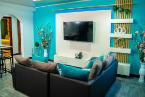 a living room with blue walls and a couch with pillows at Escappé Suites 