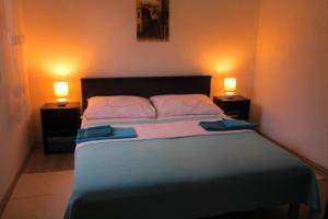 sypialnia z dużym łóżkiem z 2 lampami w obiekcie Holiday Home Mirta w Pakoštane