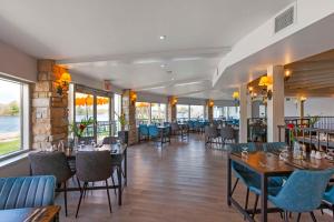 a restaurant with tables and chairs and windows at Christie's Mill Inn & Spa - BW Premier Collection in Port Severn