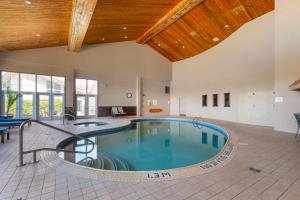 a large indoor swimming pool with a wooden ceiling at Christie's Mill Inn & Spa - BW Premier Collection in Port Severn