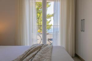 a bedroom with a bed and a view of a balcony at Apartments Maris in Baška Voda