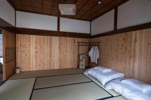 Habitación con 2 camas en una habitación con paredes de madera. en guesthouse碧, en Okinoshima