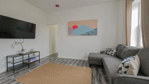 een woonkamer met een bank en een flatscreen-tv bij Atlantic Suite by the Boardwalk 3B in Atlantic City